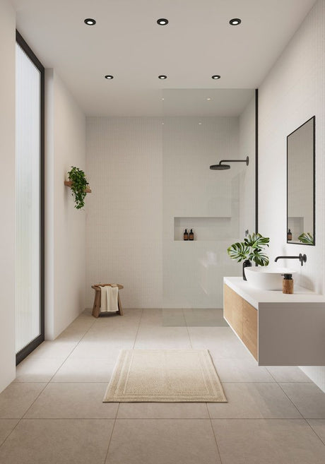 Helles Badezimmer mit Einbaustrahlern, moderner Duschkabine und minimalistischer Einrichtung.