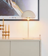 Beige Tischleuchte Ellen im minimalistischen skandinavischen Design auf einem Sideboard, umgeben von Kerzen.