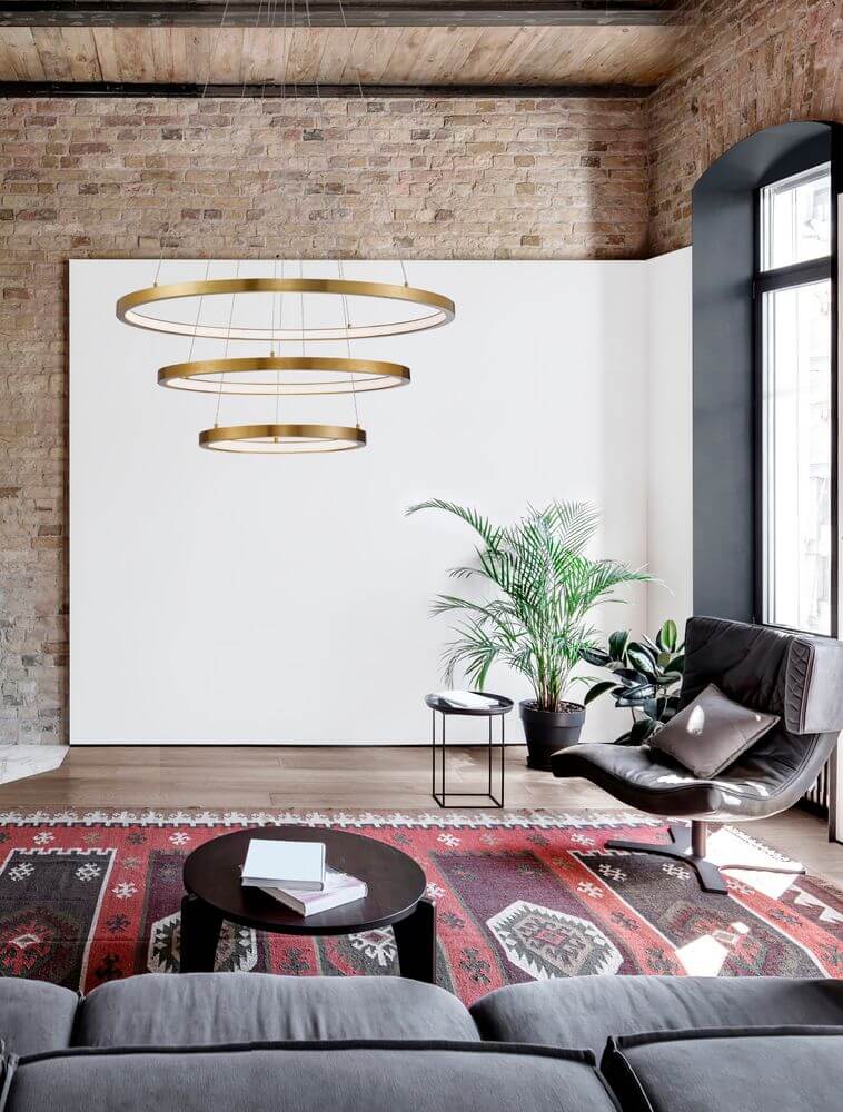 Empatia LED Pendelleuchte 3-flammig Ø 80cm 3000K im modernen Wohnraum mit Pflanzen und stilvollem Mobiliar.