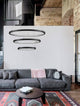 Empatia LED Pendelleuchte 3-flammig Ø 80cm 3000K über modernem Wohnzimmer mit Sofa und Teppich.
