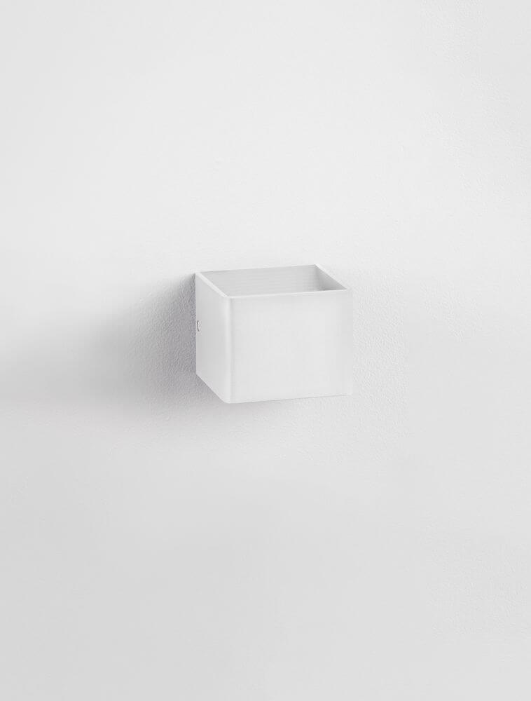 Weißer quaderförmiger Wandbehälter in minimalistischem Design an einer Wand montiert.