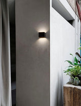 Epic LED Wandleuchte in Schwarz an einer Wand mit stilvollem indirektem Licht und modernen Pflanzen.