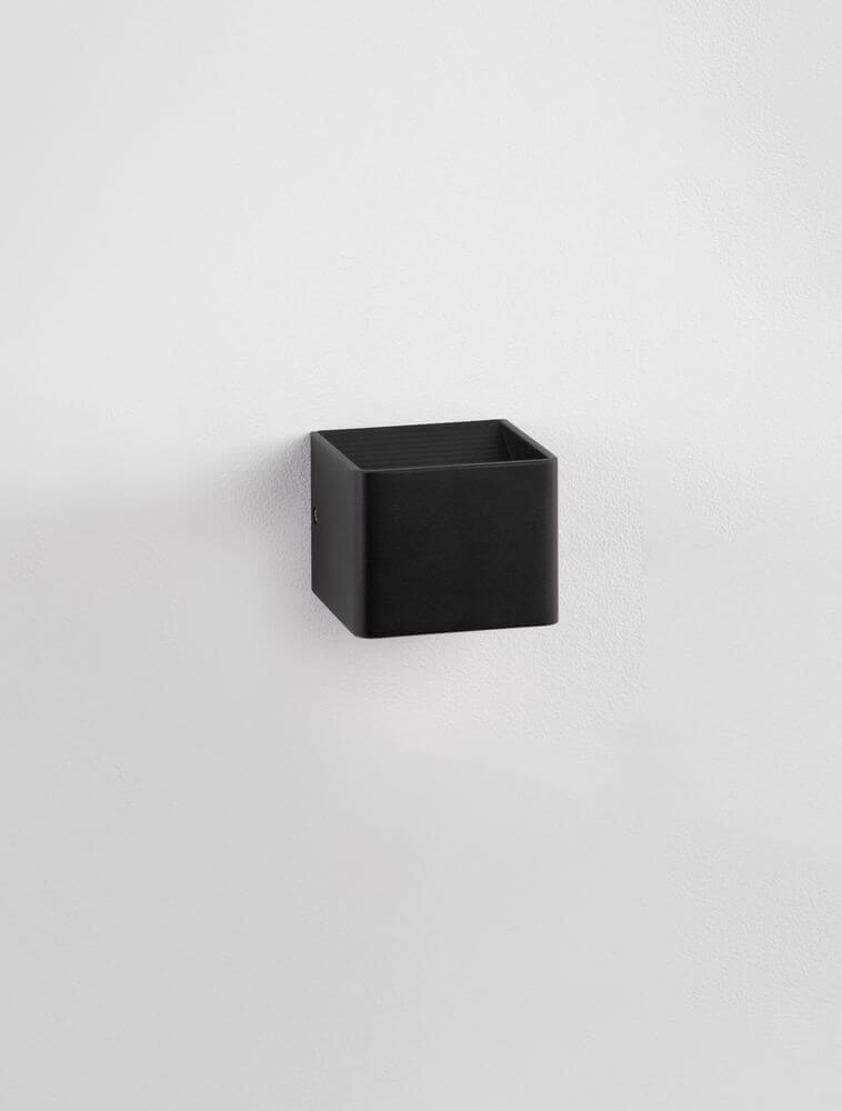 Schwarze, quaderförmige LED Wandleuchte, moderne und minimalistische Inneneinrichtung, indirekte Beleuchtung.