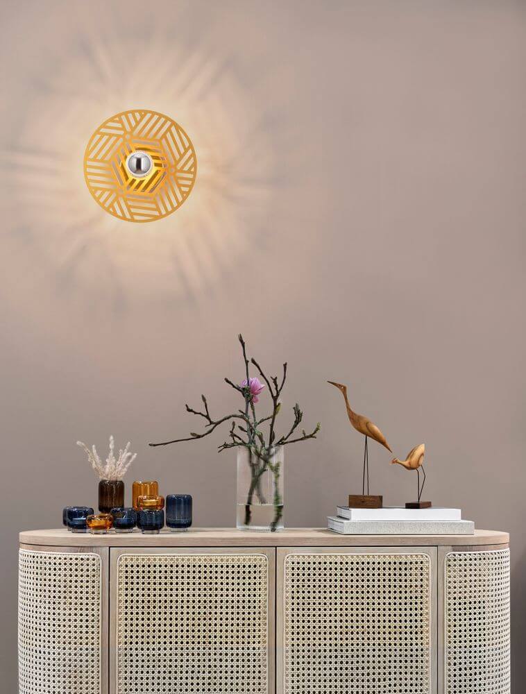 Eres Wandleuchte E27 Ø 25cm Gold über einem eleganten Sideboard mit Dekoration.