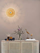 Eres Wandleuchte E27 Ø 25cm Gold über einem eleganten Sideboard mit Dekoration.