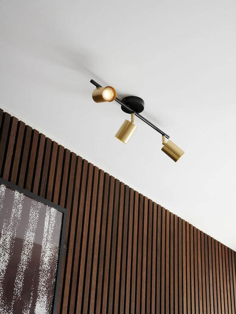 Explore 3 Spotlight in elegantem Design mit 3 goldenen Strahlern an einer Holzvertäfelung.