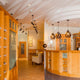 Moderne Innenansicht mit Holzregalen und stilvollen Deckenleuchten im Empfangsbereich.
