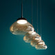 Arabella LED Pendellampe 4-flammig Glas in stilvollem Design mit geblasenem Glas über grünem Hintergrund.