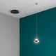 Arabella LED Pendellampe Glas in modernem Interieur mit schwarzem Deckenanschluss und grünem Wandhintergrund.