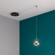 Arabella LED Glas-Pendellampe mit modernem Design und flexiblem Leuchtenkabel auf türkisem Hintergrund.