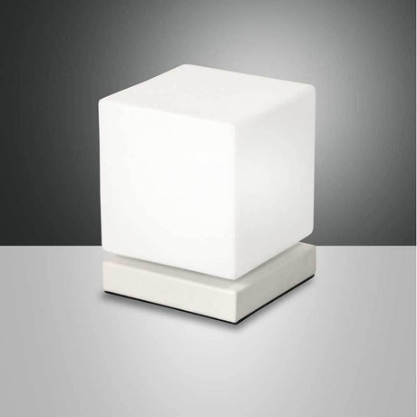 Lampe de table Brenta LED en métal sur une table moderne, offrant une lumière élégante et un design contemporain.