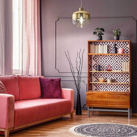 Cathy pendant light metal above a modern living room with a pink sofa and wooden shelf.