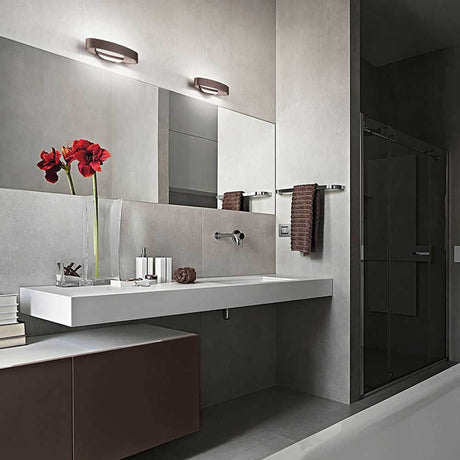 Gaby LED Wandlampe Metall über modernem Badezimmeranwesen mit eleganten Accessoires.