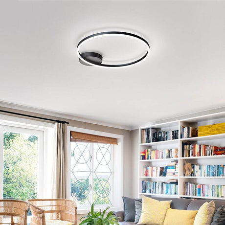 Giotto LED Deckenleuchte Schwarz in modernem Wohnraum mit Bücherregal und Fenster.