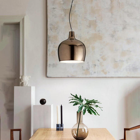 Glossy Pendelleuchte Metall über einem Holztisch mit Dekoration und Pflanzen im modernen Wohnraum.