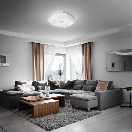 LED Deckenlampe Arbatax in Weiß in einem modernen Wohnzimmer über einer Couch.