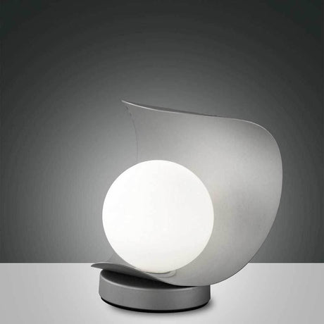 LED Tischlampe Adria aus Metall auf einem modernen Tisch, elegantes Design mit runder Leuchte.