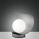 LED Tischlampe Adria aus Metall auf einem modernen Tisch, elegantes Design mit runder Leuchte.