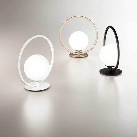 LED Tischlampe Sirio Rund in verschiedenen Farben auf einem eleganten Tisch.