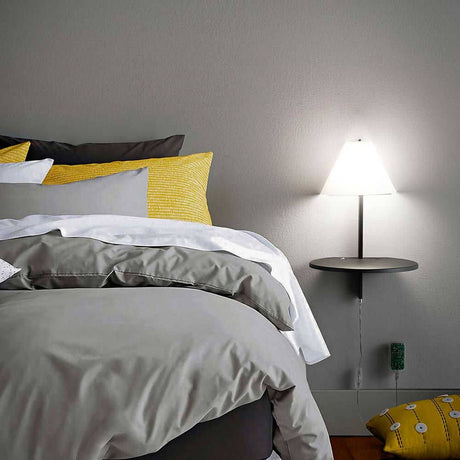 LED Wandlampe Goodnight Metall an einer Wand neben einem Bett mit gemütlicher Bettwäsche.