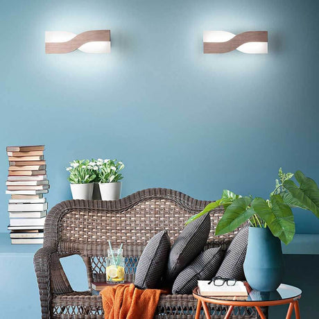 LED Wandlampe Riace Metall in modernem Raum mit bequemen Möbeln und Pflanzen.