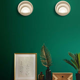 LED Wandleuchte Sunrise Ø26cm in modernem Interieur mit grüner Wand und Dekoration.