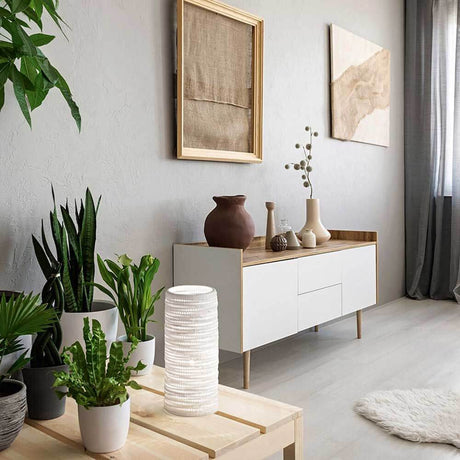Moderne Wohnzimmergestaltung mit Pflanzen, Marbella Tischleuchte Weiß und stilvollen Deko-Elementen.