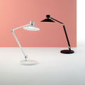 Panarea LED Tischlampe mit Touch-Dimmer in Weiß und Schwarz vor einem rosa Hintergrund.
