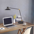 Panarea LED Tischlampe mit Touch-Dimmer auf einem Schreibtisch neben einem Laptop und einer Tasse Kaffee.