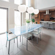 Pendant lamp Bong white above a modern dining table with blue accents and transparent chairs.
