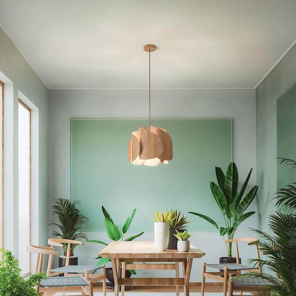 Pevero Pendelleuchte aus Massivholz in extravagant-gebogener Form über einem Tisch in modernem Raum.