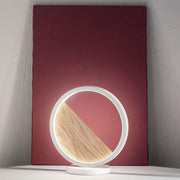 Pierre LED Metall-Tischlampe Holz auf einem minimalistischen Hintergrund mit Holz-Inlay.