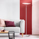 Vela LED Stehleuchte aus Metall neben einem hellgrauen Sofa in modernem Wohnraum.