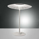 moderne LED Tischlampe Vela Weiß auf einem Tisch mit modernem Design und leuchtendem Licht.