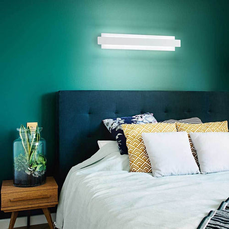 moderne LED Wandleuchte Regolo über einem Bett in modernem Schlafzimmer mit grüner Wand