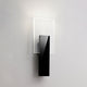 Fabbian Amulette LED-Wandlampe mit geripptem Glasdiffusor und schwarzem Metallrahmen.