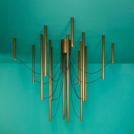 Fabbian Ari LED 16-light pendant light in bronze with black cable, modern design on a turquoise background.