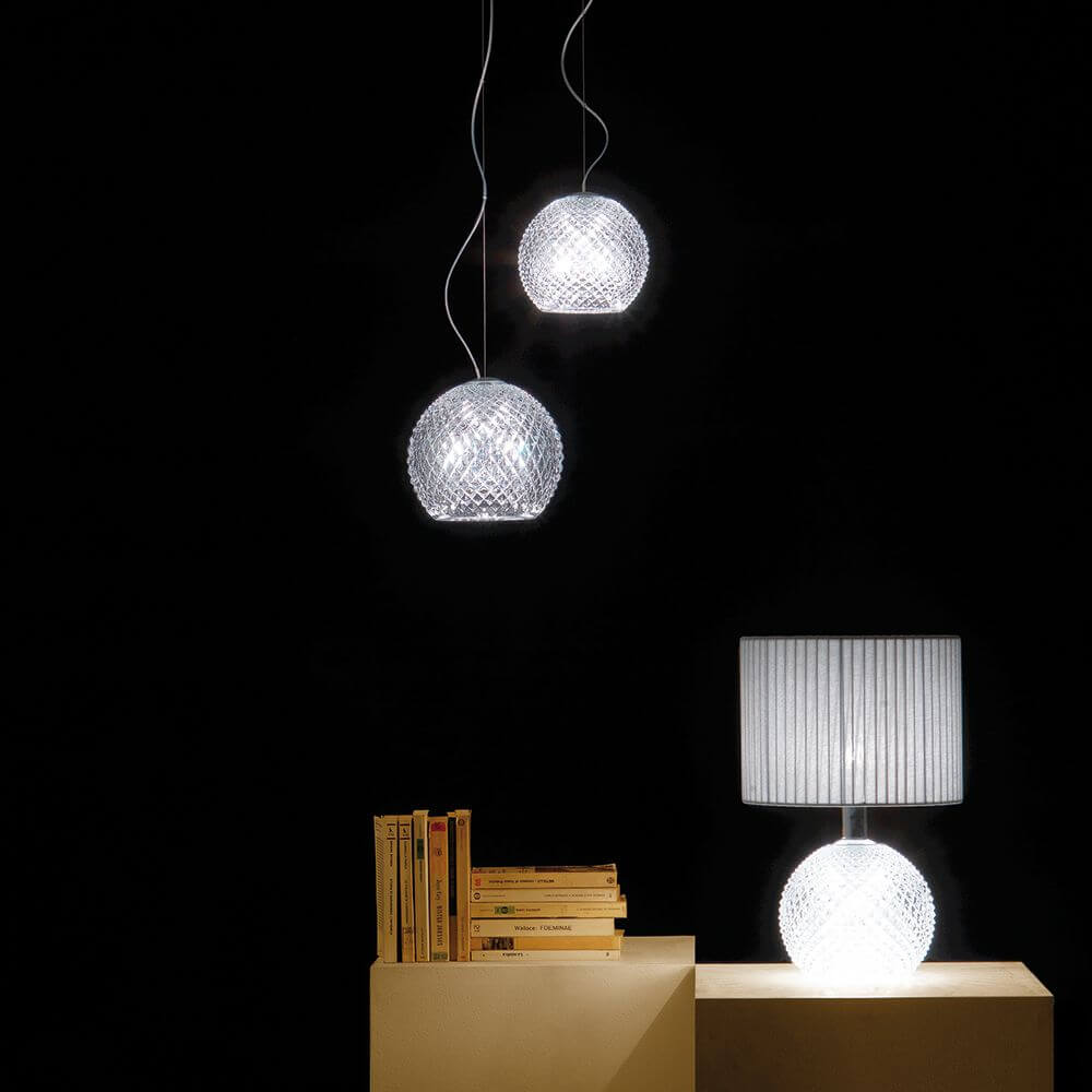 Fabbian Diamond&Swirl Pendelleuchte Diamond Ø 18cm über einem Tisch mit einer Tischlampe.