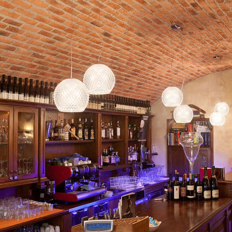 Fabbian Diamond&Swirl pendant light Diamond Ø 22 cm above an elegant bar with wine racks.