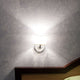 Fabbian Diamond&Swirl Wandlampe an einer Wand mit warmem Licht, perfekt für elegante Wohnräume.