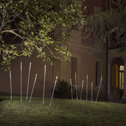 Fabbian Giunco Außen-Stehleuchte Picchetto mit Spieß im Garten bei Nacht, elegante Lichtakzente im Freien.