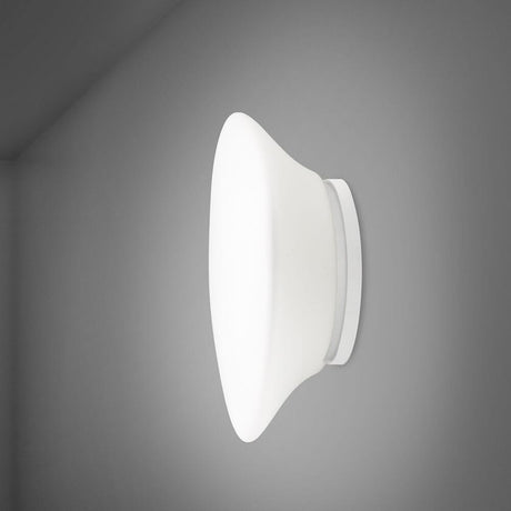 Fabbian Lumi Wandleuchte Mycena Small an einer grauen Wand montiert, mit elegantem Design und weißem Diffusor.