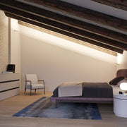 Fabbian Metro LED-Strip-Leuchte 6m im modernen Schlafzimmer mit schrägen Deckenbalken.