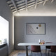 Moderne Esszimmeransicht mit Fabbian Metro LED-Strip-Leuchte und geometrischem Wandbild.