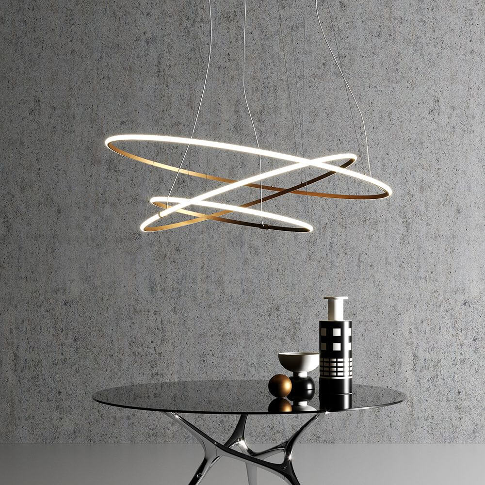 Fabbian Olympic Power LED-Hängeleuchte 3-flammig über einem modernen Tisch mit dekorativen Objekten.