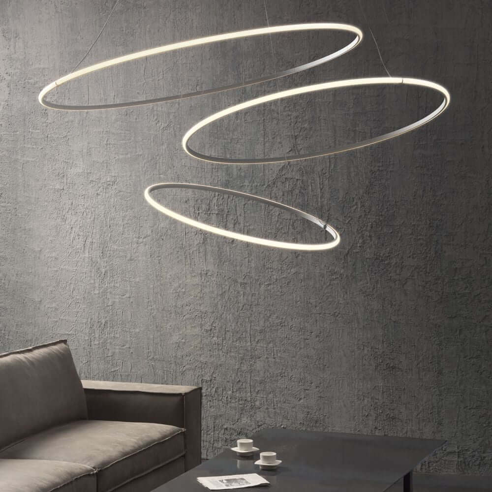 Fabbian Olympic Power LED-Hängeleuchte 3-flammig in modernem Design über einem Tisch und Sofa.