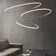 Fabbian Olympic Power LED-Hängeleuchte 3-flammig in modernem Design über einem Tisch und Sofa.