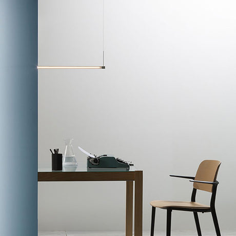 Moderne Fabbian Pivot LED-Hängeleuchte über einem eleganten Holztisch im minimalistischen Arbeitsbereich.