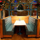 Gemütliche Sitzbank mit Tisch und Fabbian Roofer Hängeleuchte Steeple in einem modern gestalteten Restaurant.