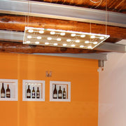 Fabbian Sospesa pendant light, 24-light, floats elegantly above an orange wall design.